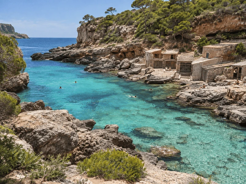 Cala s'Almunia, pequeña cala rocosa con casetas de pescadores en Mallorca