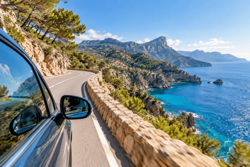 Coche de alquiler de K10 Mobility en una carretera costera de Mallorca